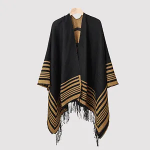 Detailed view of the striped knit poncho featuring black and tan fringe tassels.