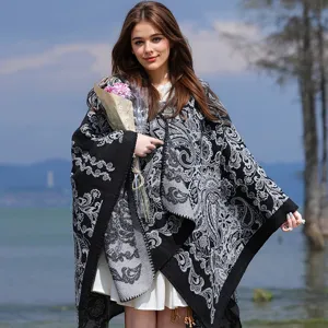 Detailansicht eines eleganten Ponchos mit Blumenmuster in einer herbstlichen Umgebung