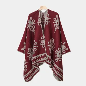 Detailaufnahme des bordeauxroten Strickponchos mit elegantem Blumenmuster und Schlitz