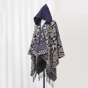 Detailaufnahme eines böhmischen Strickponchos mit Kapuze, Ethno-Muster und Fransen.