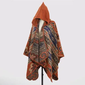 Detailansicht eines gestrickten Ponchos mit Kapuze, Tribal-Mustern und warmen Tönen.