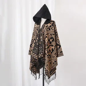 Detailansicht des Herren-Strickponchos mit Kapuze, Mustern und Fransenbesatz.