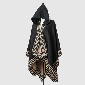 Close-up view of a premium black hooded knit poncho featuring an elegant tan meander pattern border