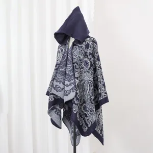 Detaillierte Nahaufnahme eines dunkelblauen Strick-Ponchos mit Paisley-Muster und Kapuze