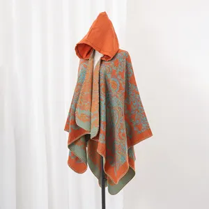 Nahaufnahme des orange-türkisen, gestrickten Kapuzenponchos mit Paisley-Muster