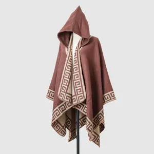Detail of brown hooded knit poncho featuring a beige geometric Greek key border pattern