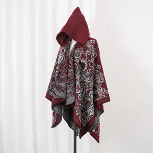 Detailansicht des roten geblümten Strick-Ponchos mit Kapuze auf einer Schaufensterpuppe