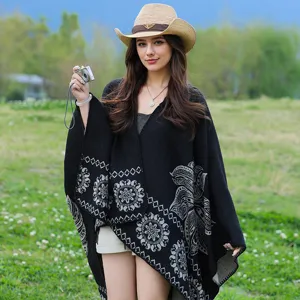 Eine Detailansicht eines warmen, schwarzen Strick-Ponchos mit grauen ethnischen Mustern