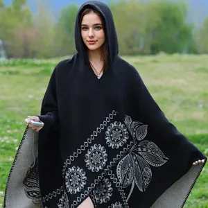 Elegante Detailansicht eines schwarzen Kapuzenponchos mit grauen ethnischen Blumenmustern.