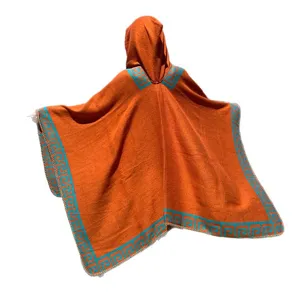 Warm orange hooded knit poncho featuring a blue geometric border for women's travel and casual wear