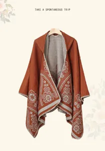 Detailansicht eines modischen terrakottafarbenen Kapuzenponchos mit weißen Blumenmustern