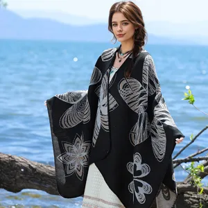 Model trägt ein elegantes schwarzes Stricktuch mit floralen Mustern an einem ruhigen See