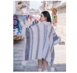 Rückansicht eines ethnischen Strickschals mit übergroßem Kunstpelzkragen und Bommel-Details