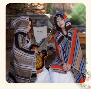 Ethnic bohemian striped hooded poncho shawl worn by models in a scenic outdoor setting