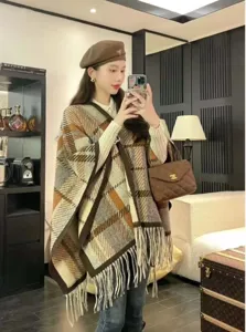 Detaillierte Ansicht des karierten Wollponchos mit Fransen und einer weichen Textur