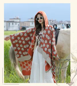 Hooded boho poncho with floral knit pattern for travel, styled with white horse outdoors.