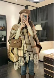 Stilvoller karierter Wollponcho mit dekorativen Fransen, perfekt für einen schicken Winterlook.