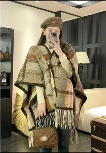 Detailansicht einer eleganten Frau mit einem braunen Wollschal mit langen Fransen.