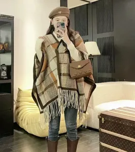 Detail eines braun karierten Wollponcho-Schals mit Fransen für Damen in Lifestyle-Ansicht