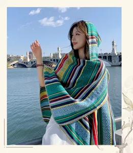 Close-up of ethnic colorful striped hooded shawl on model by the water