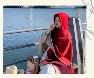 Elegant model met een rood en grijs verloop sjaal met capuchon en franjes buiten