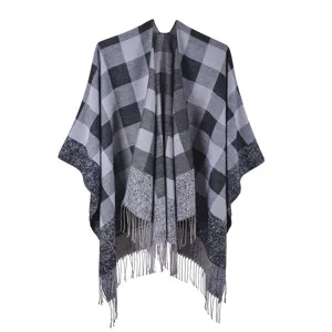 Detailed view of a retro ethnic grey and black checkered poncho with decorative tassels