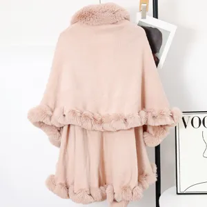 Detail view of stylish pink knit cape coat with soft faux fur collar and double-layer trim