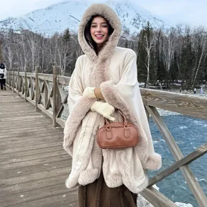 Gros plan sur un poncho en tricot à capuche pour femme avec bordure en fausse fourrure