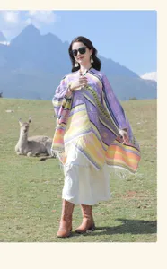 Bohemian Strick-Poncho im Ethno-Stil mit bunten geometrischen Mustern in Bergkulisse