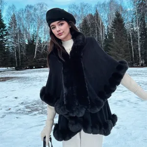 Elegant black knit poncho with lush faux fur collar and trim for winter outdoor styling