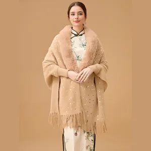 Detail of elegant beige knitted shawl with faux fur collar and shiny sequins decoration
