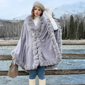 Grey mid-length poncho with a large faux fur collar worn in a snowy outdoor scene