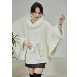 Elegant white faux mink fur cape featuring a large fur collar and stylish pom-pom belt detail