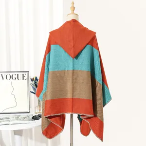 Back view detail of a hooded knit poncho featuring vibrant orange and teal stripes