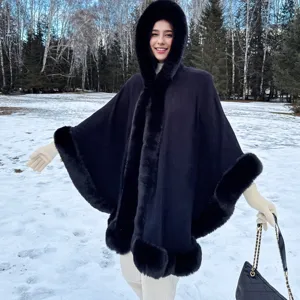 Vue détaillée d'un poncho tricoté noir chaud avec capuche et bordure en fausse fourrure