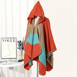 Detailed view of colorblock hooded knit poncho with orange, teal and brown patterns