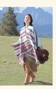 Ethno-Strickschal mit Fransen und geometrischen Mustern in einer Berglandschaft im Freien.