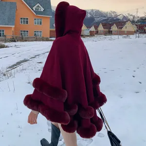 Poncho à capuche bordeaux avec bordure en fausse fourrure dans la neige