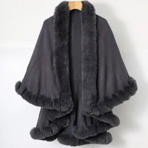 Detail shot of a dark grey knitted shawl featuring plush faux fur trim and dual layers.
