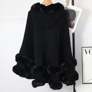 Détail d'un poncho en tricot noir à capuche avec une épaisse bordure en fourrure