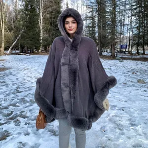 Élégant poncho à capuche en tricot gris avec bordure en fausse fourrure pour la chaleur d'hiver