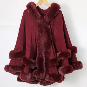 Poncho tricoté à capuche bordeaux avec garniture en fausse fourrure pour la mode hivernale