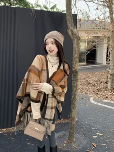 Modischer Maillard-Plaid-Schal-Poncho mit Fransen-Detail am Modell in herbstlicher Parkkulisse.