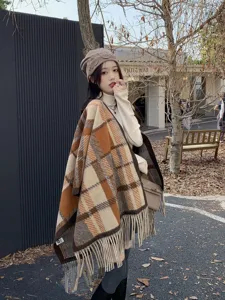 Nahaufnahme eines Models mit Maillard-Karo-Strickschal-Poncho in einer Herbststraße