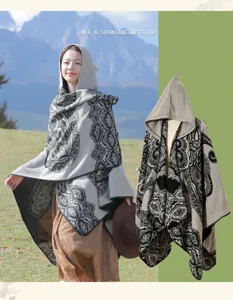 Asiatisches Model mit ethnischem Kapuzenponcho in malerischer Berglandschaft
