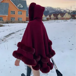Élégante cape en tricot bordeaux avec capuche, bordure en fourrure et pompons pour l'hiver
