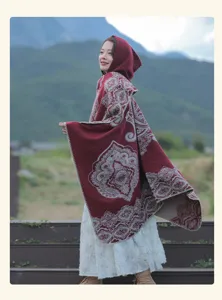 Eleganter ethnischer Kapuzenumhang mit rotem Vintage-Muster im Freien getragen.