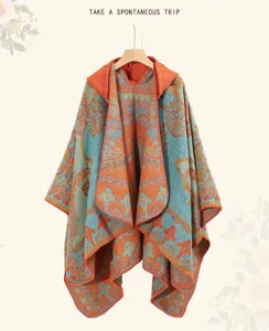 Dettaglio ravvicinato dei motivi floreali etnici su un poncho in maglia colorato con cappuccio