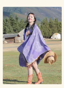 Etnischer lila Schal mit Fransen in einer Graslandschaft im Freien fotografiert