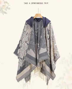 Vue détaillée d'un poncho à capuche tricoté avec des pompons et motif jacquard
